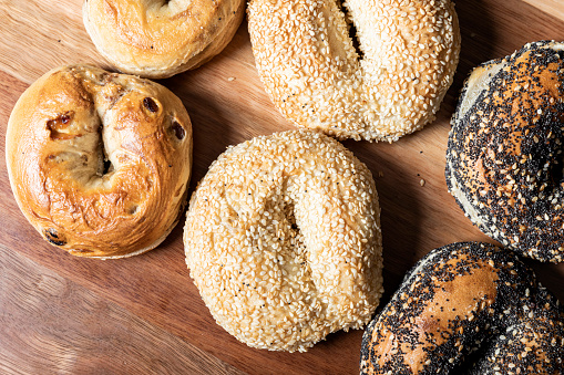 Detailed close-up of freshly baked bagels, generously topped with whole grain seeds.