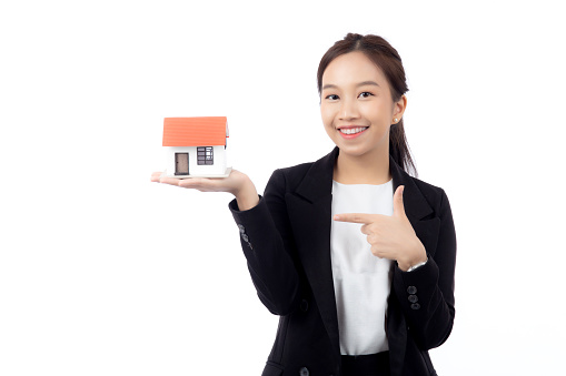 Portrait young asian businesswoman holding house for mortgage isolated white background, agent insurance business woman holding home for investment and presenting, female show home with excited.