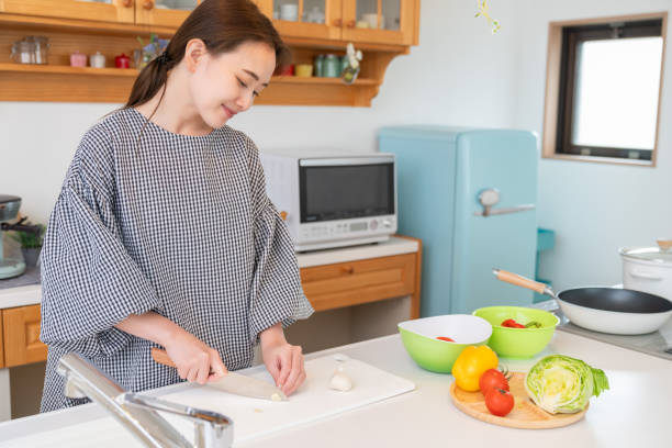 istock asian woman cooks in a kitchen,garlic 1956340532