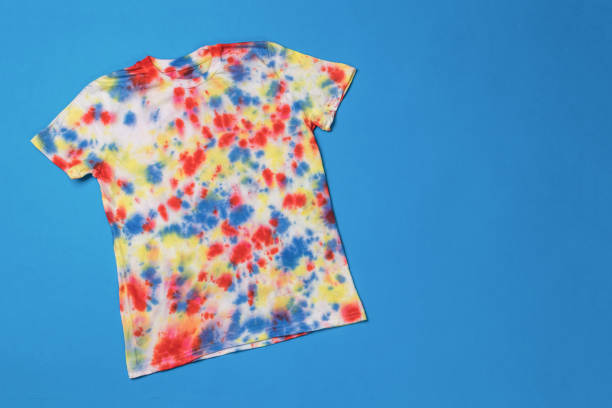 istock A bright colorful tie dye T-shirt on a blue background. 1956346817