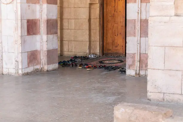 Photo of Believers' shoes left in front of the entrance to the Muslim mosque.