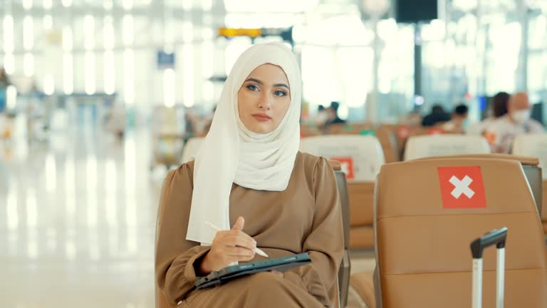 Asian Young female passenger waiting for flight at departure area airport