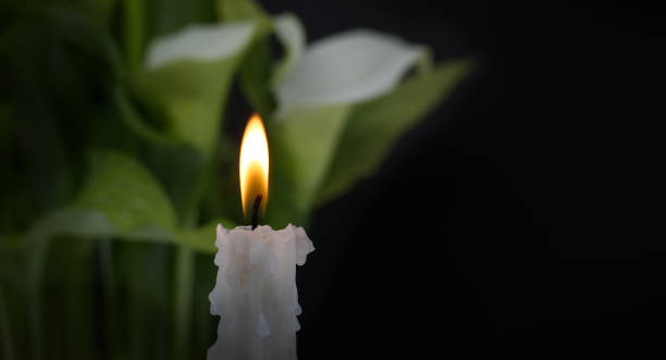 istock Burning wax candle in close up and white calla lily 1956522784