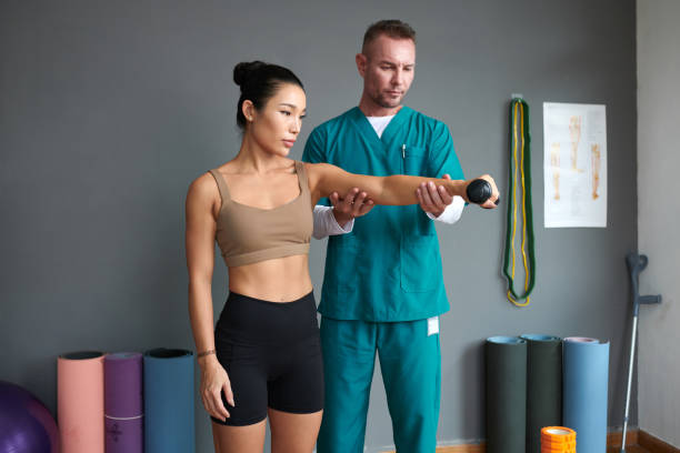 istock Sportswoman Exercising under Control of Physiotherapist 1956522845