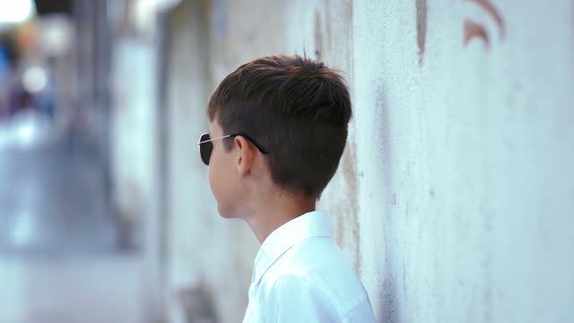 Sunny Day Wonder: Boy in Sunglasses Observing the Outdoors