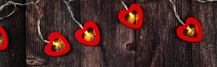 Garland with hearts on wooden background. Valentine's Day celebration. Banner.