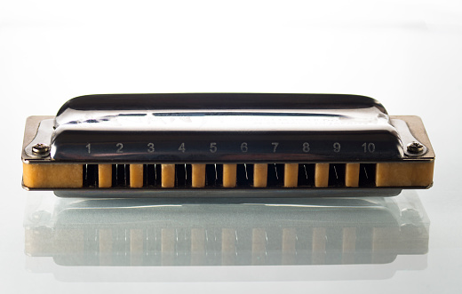One harmonica on a white background
