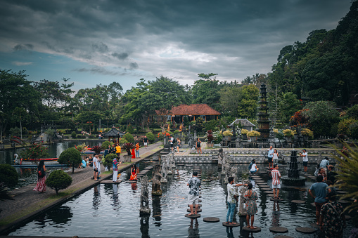 Bali, Indonesia - October 11, 2022: \nBusy scene with tourists take photos at a popular tourist destination in Bali, Tirta Gangga Water Palace.