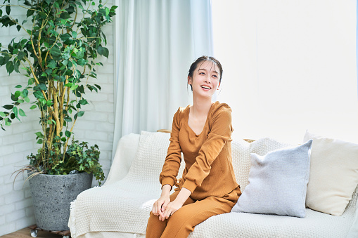 Smiling young woman wearing loungewear relaxing in her room