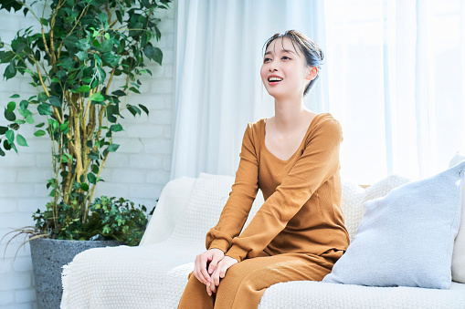 Smiling young woman wearing loungewear relaxing in her room