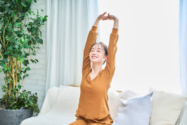 部屋着を着て深呼吸をする若い女性 - 深呼吸 ストックフォトと画像