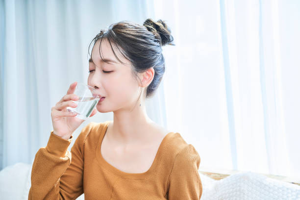 istock Young woman drinking water in the room 1956745302