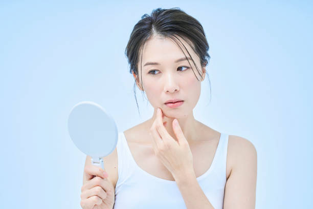 istock A woman with an anxious expression checking her skin condition 1956765504