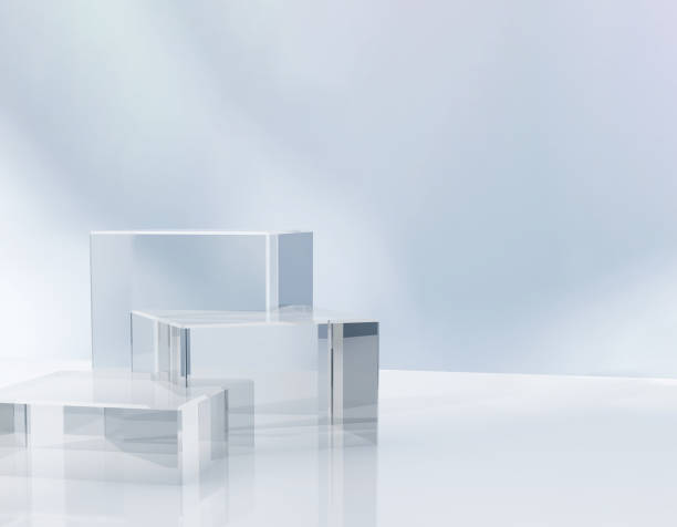 istock Three modern transparent cuboid podium, geometric pedestal on white counter, dappled light on blue wall 1956769101