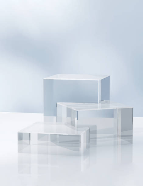 istock Three modern transparent cuboid podium, geometric pedestal on white counter, dappled light on blue wall 1956769106