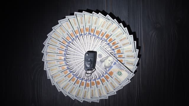 Dollar banknotes in the shape of a circle are spinning on a wooden table
