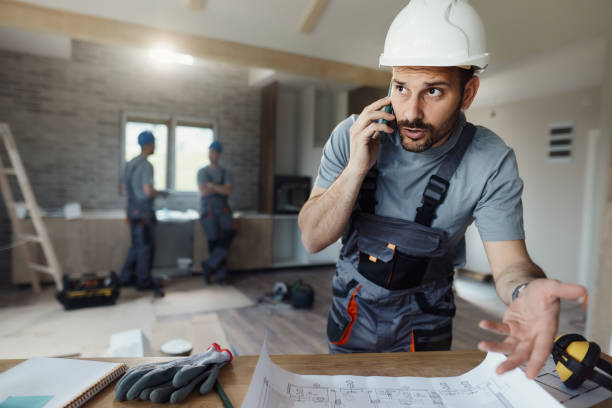 istock Displeased manual worker talking on cell phone during home renovation process. 1956802543