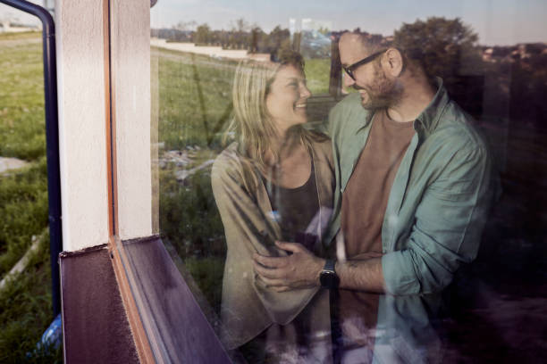 istock Happy couple talking by the window at home. 1956805201