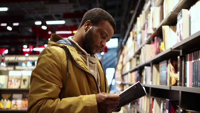 African American man decides which book to buy in bookstore