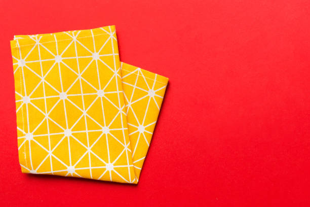 istock top view with yellow empty kitchen napkin isolated on table background. Folded cloth for mockup with copy space, Flat lay. Minimal style 1956823377