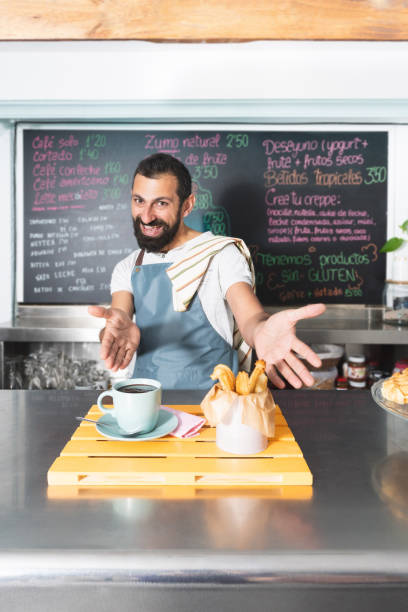 istock Funny ethnic Turkish-German waiter offering his products. 1956847144