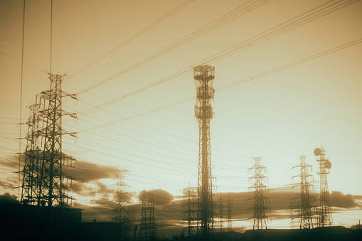An image of a power transmission tower that is vaguely visible in the evening