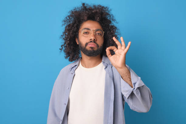 istock Young self-confident arrogant Arabian man shows okay sign stands in studio 1956868890