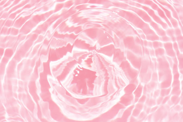 istock Red water background. Red water splashes on the surface ripple blur. Defocus blurred transparent pink colored clear calm water surface texture with splash and bubble. Red water waves shine. 1956869437