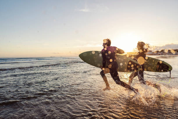 istock Surfers rushing into the water with surfboards. 1956928550
