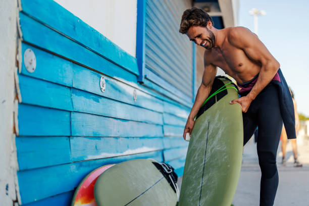 istock A tanned surfer preparing his surfboard. 1956929121