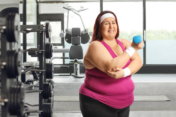 istock Plus size female exercising at a gym and holding her elbow 1956930816