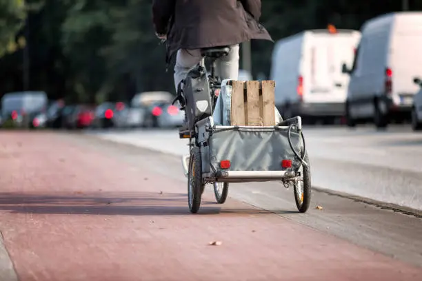 Cyclist transports wooden box with bicycle trailer