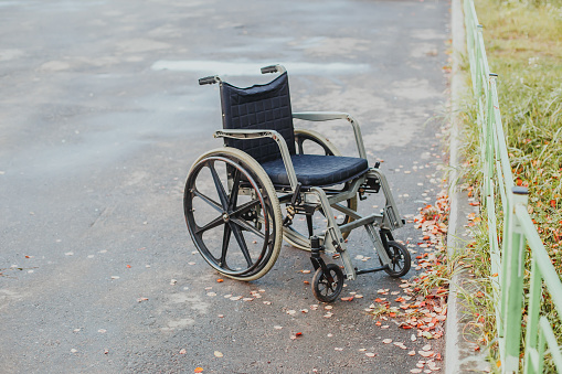 lonely abandoned wheelchair outdoors in autumn