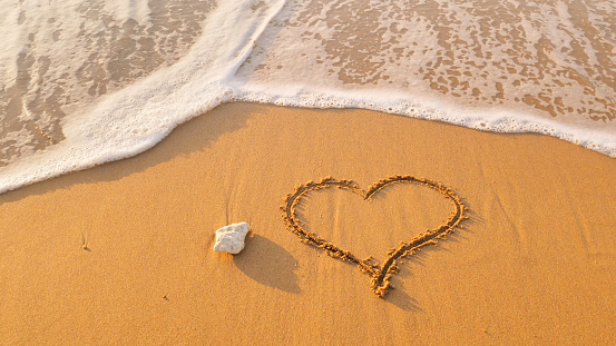 Heart symbol on sea shore beach. Romantic composition.