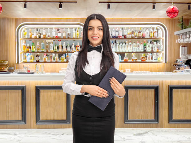 istock Waitress holding a menu and standing at a bar 1956941713