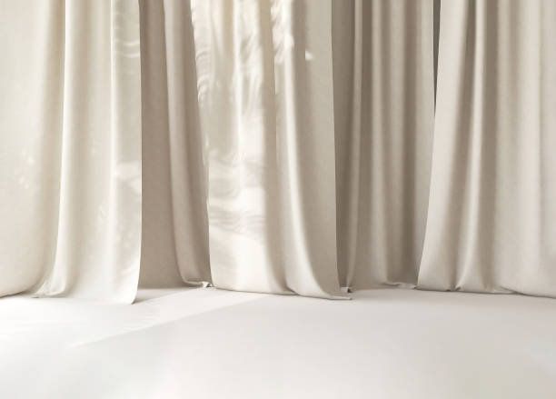 istock Modern beige cream drapery curtain on white stage floor in sunlight from window 1957008975