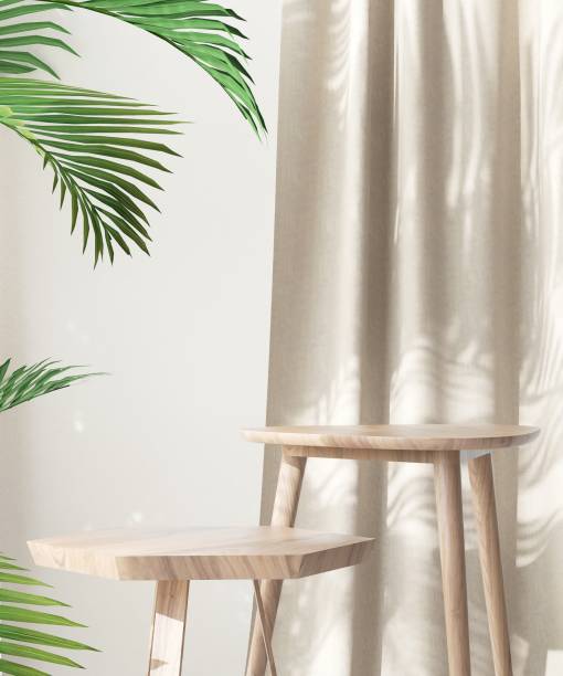 istock Two wooden geometric shape brown chairs, different height in sunlight on palm leaf, beige curtain, wall in background 1957009503