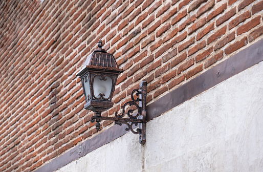 Vintage style lantern lamp. Sconce lighting lamp on historic brick wall.