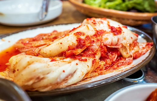 Dish of Korean Kimchi commonly served as a side dish during meal times. Traditional food of salted, spiced fermented cabbage or radish. Healthy foodstuff to support nutrition and health.
