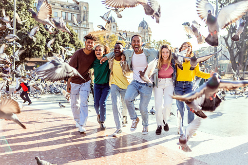 Multiracial group of young best friends having fun together in Barcelona. Millennial diverse tourist enjoying holidays in Spain