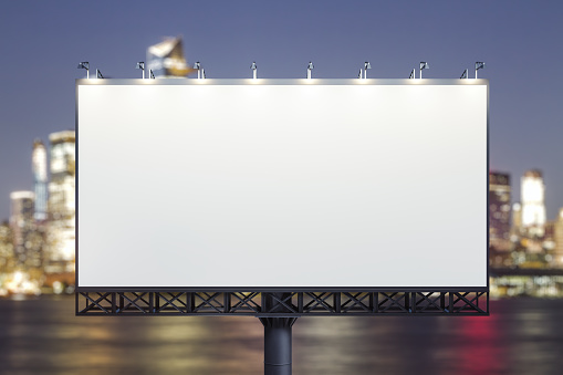 Blank white billboard on cityscape background at evening, front view. Mock up, advertising concept