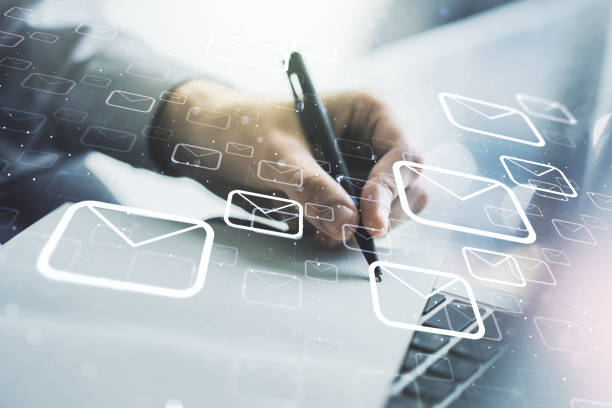 istock Creative abstract postal envelopes hologram with hand writing in diary on background with laptop, email and notification concept. Multiexposure 1957071201