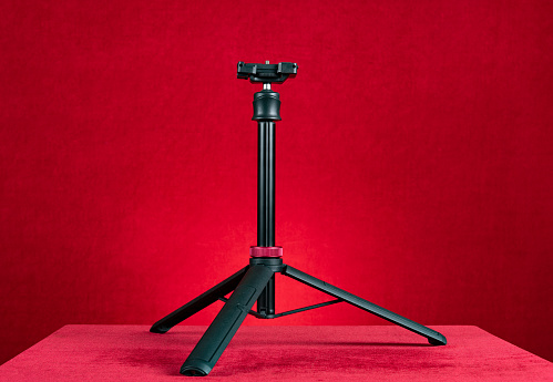a thin tripod on a red background