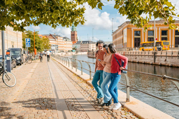 istock Three Young Friends Using Smart Phone In Copenhagen In Denmark 1957085356