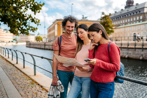 istock Three Young Friends Reading A Map In Copenhagen In Denmark 1957087007