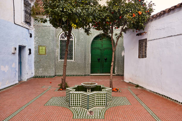 фасад здания исламской школы завия с фонтаном в шефшауэне, марокко - fountain courtyard tile wall стоковые фото и изображения