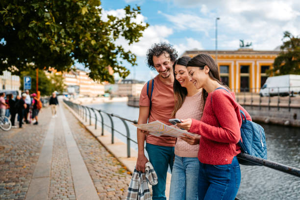 istock Three Young Friends Reading A Map In Copenhagen In Denmark 1957088187