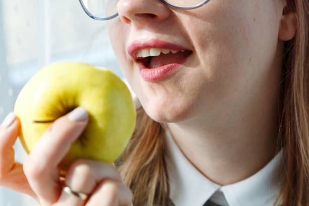 Close up of woman's mouth eating apple stock photo