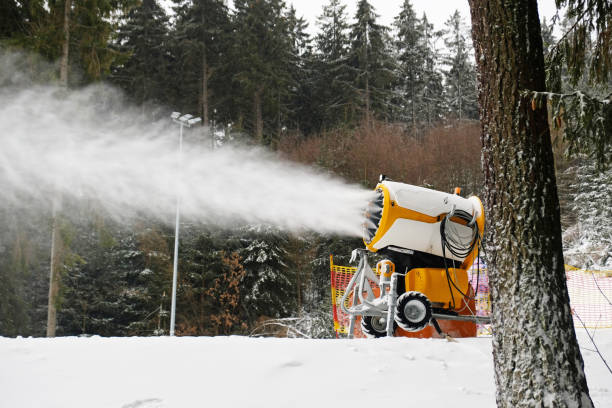 Snow cannon makes artificial snow. Snowmaking systems sprays water to produce snow. Preparation of ski track for skiing, winter sport. Machine making snow.