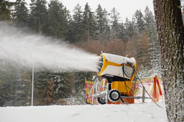 スノーキャノンは人工雪を作ります。人工降雪システムは、水を噴霧して雪を作ります。スキー、ウィンタースポーツのためのスキートラックの準備。雪を作る機械。 - mountain winter season machine snow making machine ストックフォトと画像